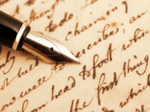 Pennino d'oro su pergamena antica, evocando il significato epistolare di un tempo.