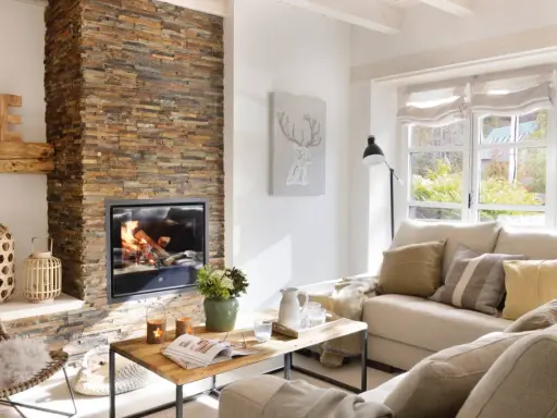 Acogedor salón moderno con chimenea de leña, sofá beige y mesa de centro de madera.