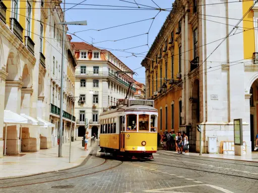 Gelber Oldtimer-Tram fährt durch Lissabon. Die Höchstgeschwindigkeit Portugals ist hier nicht relevant, aber die Atmosphäre ist unbezahlbar.