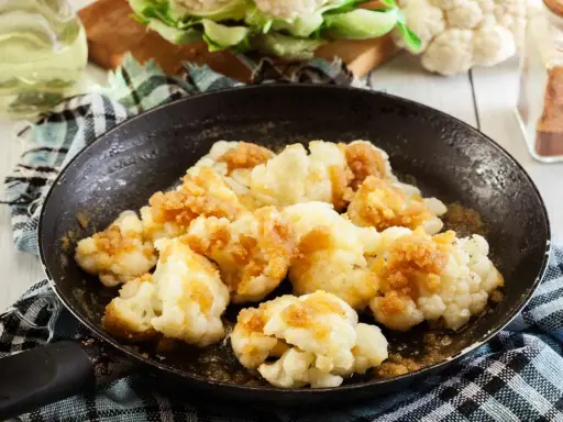 Cavolfiore in padella, dorato e saporito, pronto per essere gustato.