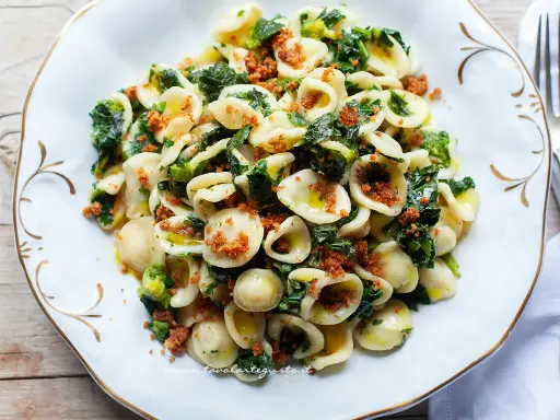 Orecchiette cime di rapa, un piatto tradizionale pugliese, condito con verdure verdi e pangrattato tostato.