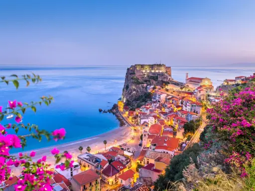 Scilla, Calabria: un borgo da sogno dove andare al mare, con il castello Ruffo a picco sul blu e fiori colorati.