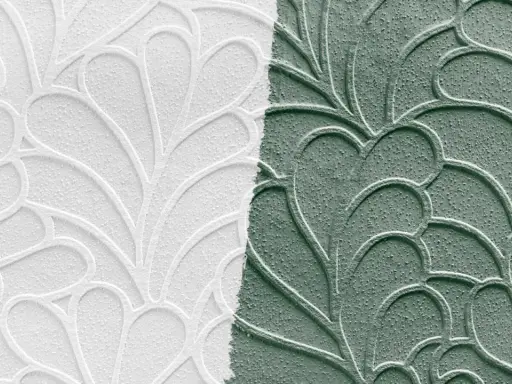 Papier peint en relief, moitié blanc, moitié vert, avec un motif de feuilles stylisées. Idéal pour peindre sur papier peint relief.