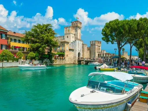 Malowniczy rejs po Jeziorze Garda. Woda lśni, a zamek Scaligero w Sirmione zaprasza do zwiedzania.