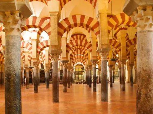 Ein Saal mit Säulen und roten und weißen Bögen, der an die Gelehrsamkeit arabischer Wissenschaftler erinnert.