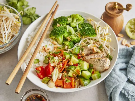 Ein bunter Asia Bowl mit Reis, Hähnchen, Brokkoli, Gurken, Tomaten und Sojasprossen. Perfekt für ein leichtes Mittagessen.
