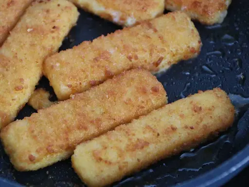 Gyldene fiskpinnar i ugn, redo att serveras. Krispiga och varma, en klassiker som alltid går hem.