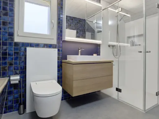 Modernt badrum med blå mosaik, flytande kommod och duschkabin. Perfekt badrum inspiration för ett stilrent hem.