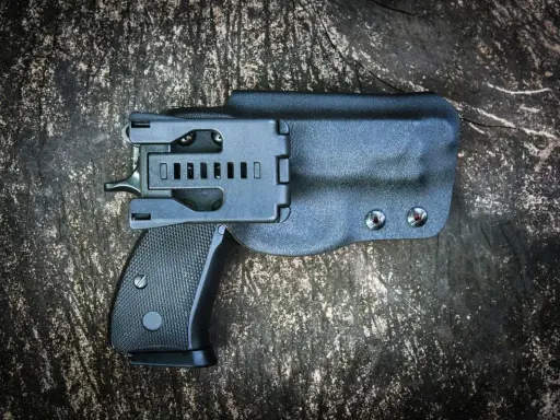 Czarna kabura wewnętrzna na broń, dyskretnie ukrywająca pistolet.