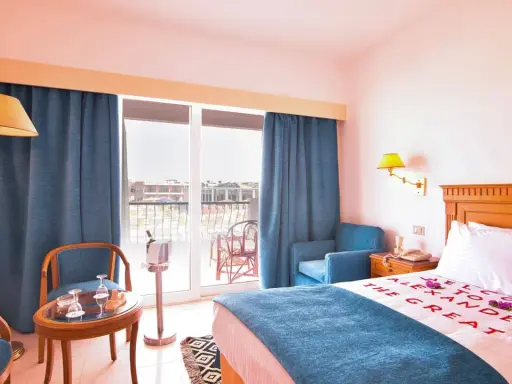 Pokój hotelowy z napisem "Welcome to Alexander the Great" na pościeli. Opinie o tym miejscu mogą być pozytywne.