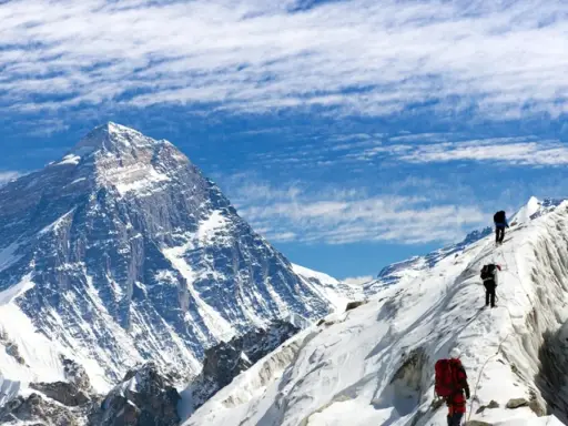 Alpinisci wspinają się na ośnieżony grzbiet, zbliżając się do jednego z najwyższych szczytów kontynentów.