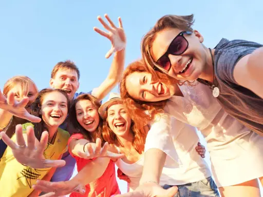 Uśmiechnięta grupa przyjaciół robi selfie. Ich radość i bliskość to czynniki chroniące przed samotnością.