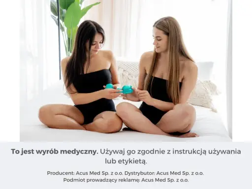 Dwie kobiety siedzą na łóżku, jedna podaje drugiej bańkę chińską na brzuch.