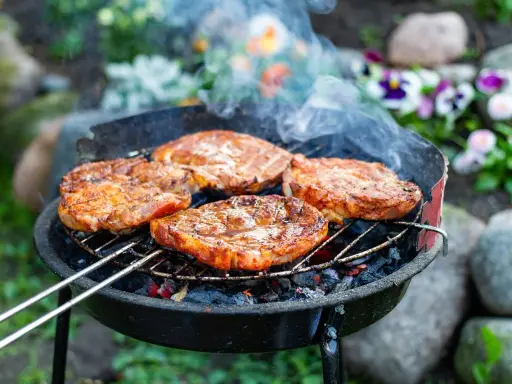 Saftige Steaks brutzeln auf dem Grill. Das Aroma von gegrilltem Fleisch liegt in der Luft.