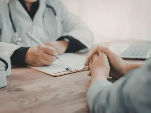 Consultation médicale : un médecin note des informations sur une liste maladie professionnelle secrétaire.