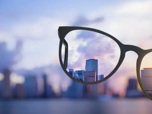 Okulary progresywne z szerokim polem widzenia wyostrzają miejski krajobraz o zachodzie słońca.