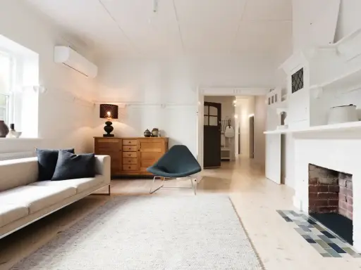 Salon lumineux avec canapé, fauteuil, buffet en bois et cheminée. Idéal pour savoir comment trouver un appartement rapidement.