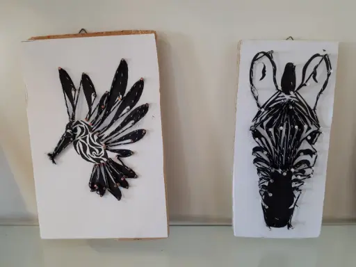 Två spik tavlor med djurmotiv: en kolibri och ett zebrans huvud, skapade med tråd och spik.
