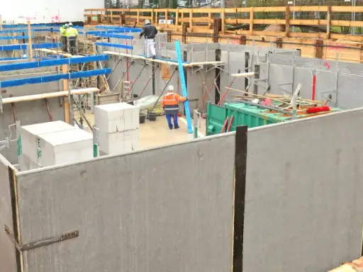 Baustelle mit WU Beton Wänden, Schalung und Arbeitern.
