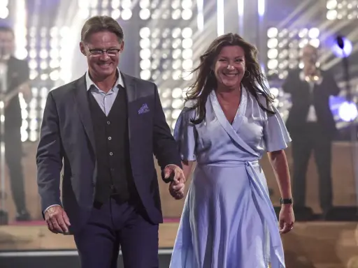 Lotta Engberg och ett leende raffset på scenen, med ett band i bakgrunden.