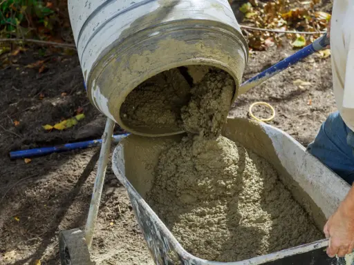 Betoniarka wylewa świeżą zaprawę do taczki. Trudno ocenić, ile worków cementu na m3 zużyto, ale efekt jest imponujący.
