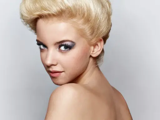 Mujer joven con peinado voluminoso y maquillaje llamativo, sus ojos de bambi cautivan la mirada.