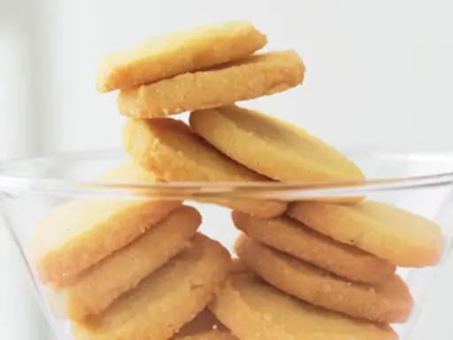 Stapel von goldbraunen Heidesand-Keksen in einer Glasbowle. Dieses Bild weckt Lust auf das beste Heidesand Rezept!