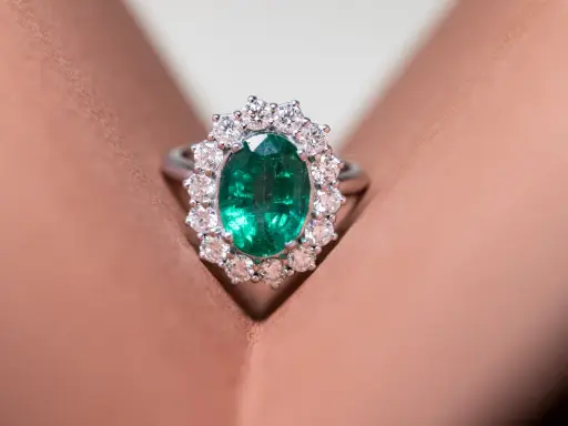 Anello con smeraldo ovale circondato da diamanti, un gioiello di grande valore, più prezioso di un rubino.