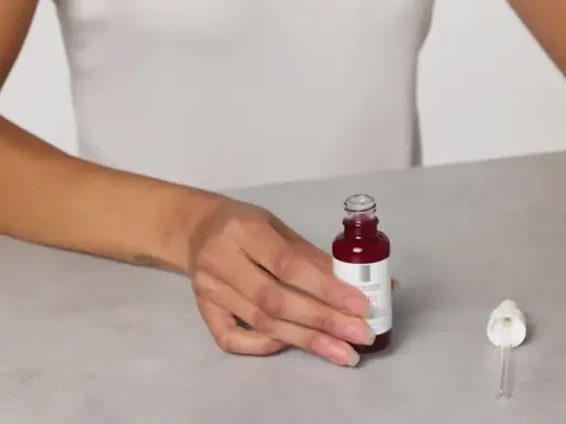 Mani che mostrano il siero Retinol B3 La Roche Posay, pronto per l'uso. Scopri come applicarlo per una pelle radiosa.