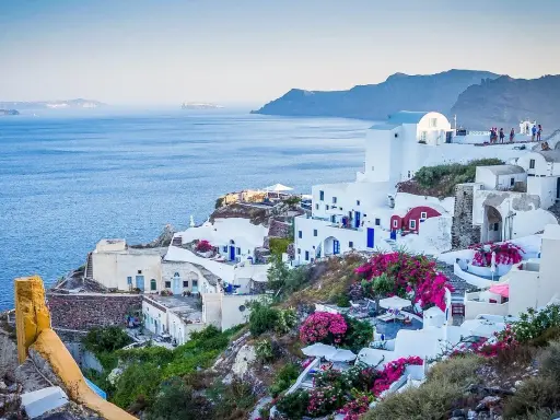 Białe domy na zboczu klifu z widokiem na morze, Santorini, Grecja.