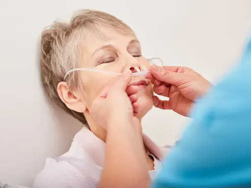 Ältere Frau mit Nasenbrille zur Sauerstofftherapie, ein Zeichen des COPD-Krankheitsbildes.
