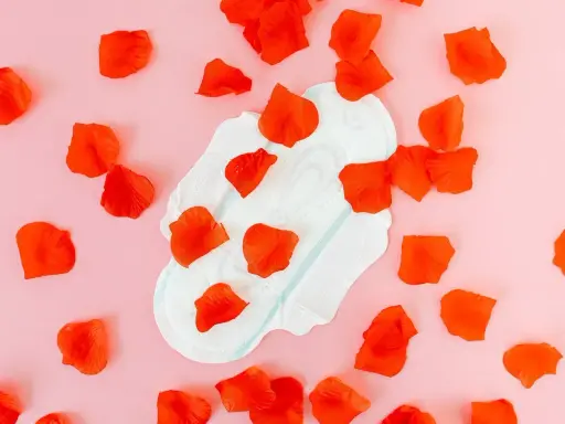 Compresa con pétalos rojos, simbolizando el sangrado después de la pastilla del día después.