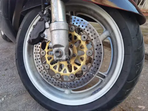 Motocykl z tarczami hamulcowymi i zaciskiem. Ostre koło hamowanie zapewnia bezpieczeństwo na drodze.