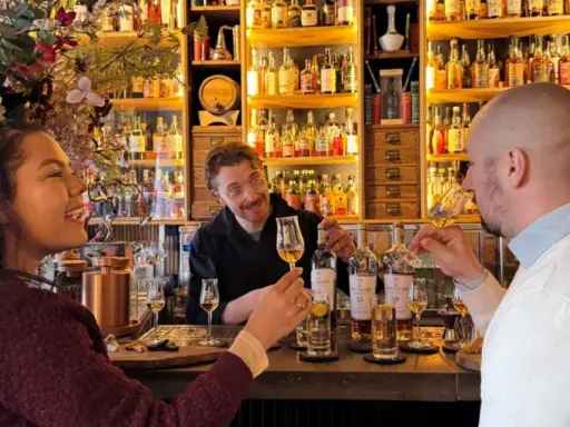 Två personer njuter av en ölprovning i Stockholm. En glad bartender serverar.