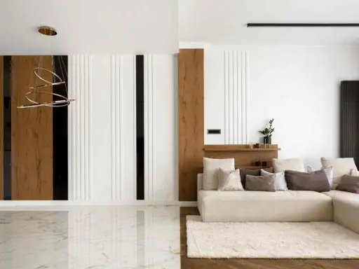 Interni di una casa minimalista con divano beige, tappeto soffice e lampadario moderno. Pareti con pannelli in legno e finiture bianche.
