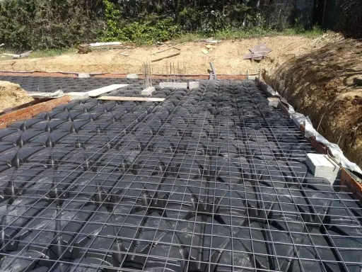 Preparación para un forjado sanitario ventilado: se aprecian los casetones negros y la malla metálica sobre ellos.