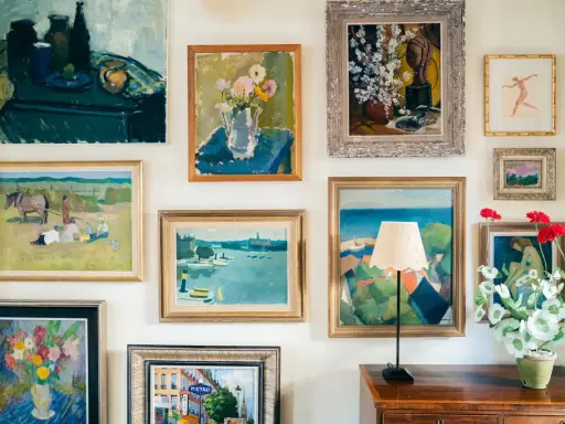 A gallery wall showcasing a diverse collection of paintings, proving that collecting art on a budget can create a vibrant and personal space.