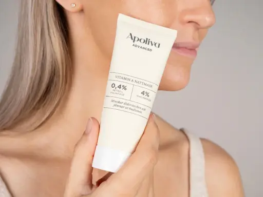 En kvinna håller en tub med Apoliva Vitamin A Nattmask. Produkten innehåller retinol och niacinamid, bra för att minska ålderstecken och motverka akne.