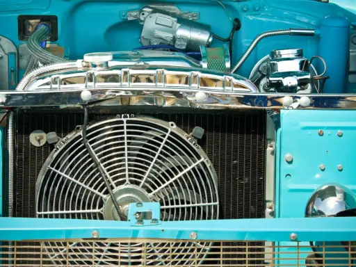 Motor de coche azul brillante con ventilador grande. ¿Por qué no salta el ventilador del coche? Quizás necesite un ajuste.