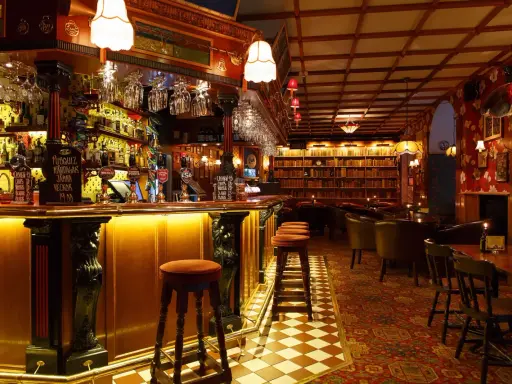 Mysig bar med bokhyllor och bekväma sittplatser, perfekt för att upptäcka Stockholms bästa barer.