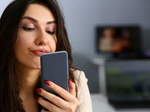 Zastanawia się, czy muszę odbierać telefon od ojca dziecka. Wyraz twarzy sugeruje niepewność.