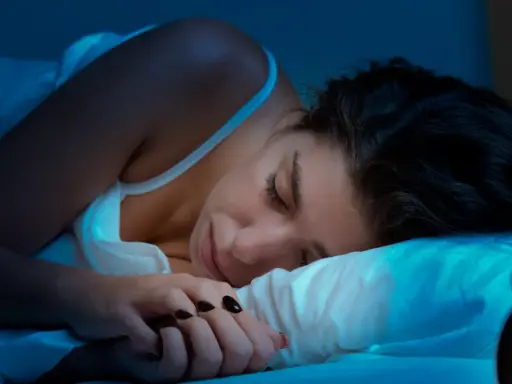 Kobieta śpi, ale budzik sugeruje, że to może być kolejna noc bez snu. Co to insomnia?