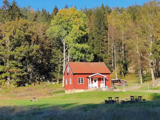 Rött hus i Svartedalen, perfekt för en vandring. Höstfärger i skogen och en solig äng.