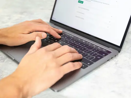 Dłonie piszą na laptopie. Może to być praca dla agencji copywriterskich, tworzenie treści lub analiza danych.