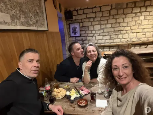 Ambiance chaleureuse dans la taverne médiévale Paris. Quatre amis partagent un repas convivial, entre rires et dégustations.