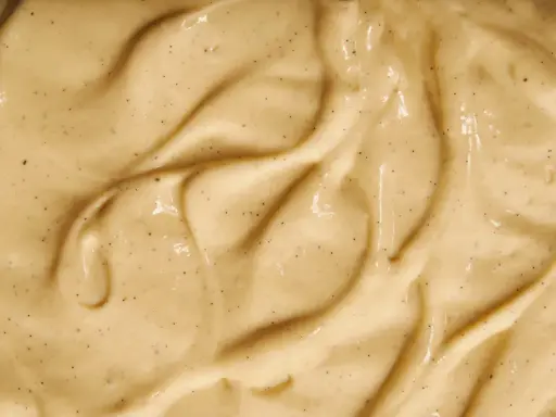 Texture onctueuse de crème pâtissière traditionnelle, parsemée de points de vanille.