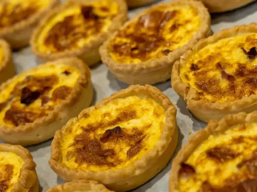 Petites quiches dorées, garnies d'une préparation crémeuse et de lardons. Un délice, une spécialité de Nancy à savourer sans attendre.