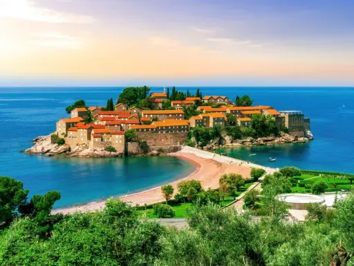 Drömresa till Montenegro: en pittoresk ö med stenhus och röda tak, omgiven av turkost hav. Perfekt för en solsemester.