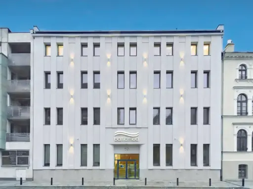 Nowoczesny, biały budynek kliniki Balticmed w Szczecinie z podświetlanym logo i oknami.