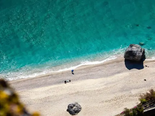 Spiaggia dorata e mare turchese in Liguria. Un pescatore solitario ammira la bellezza del **liguria mare**.
